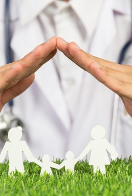 close up picture of doctor's hands posting symbol of home above family member model